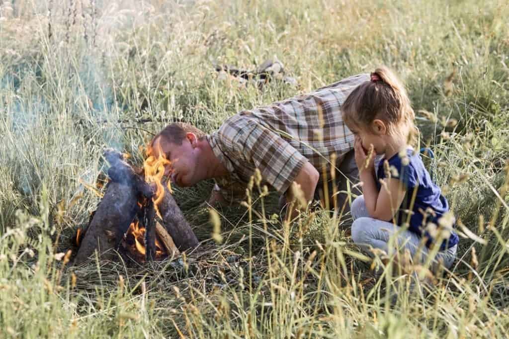 stoking a fire by blowing on it