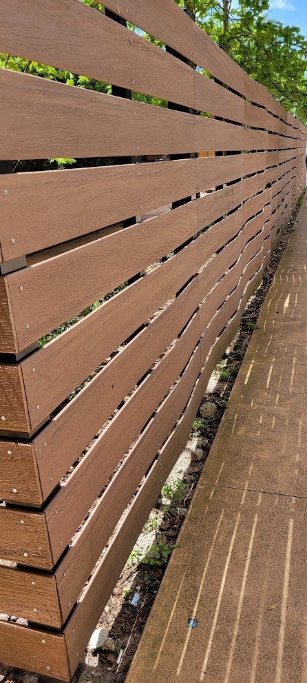 cedar horizontal metal fence with wavy boards.